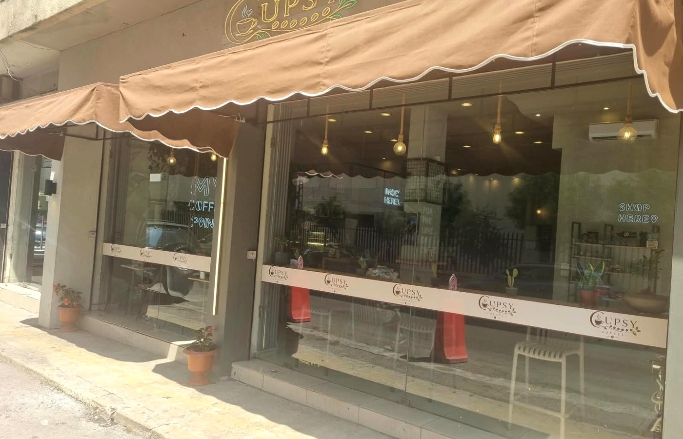 Cupsy Coffee storefront in Dora with brown awnings and a glass facade